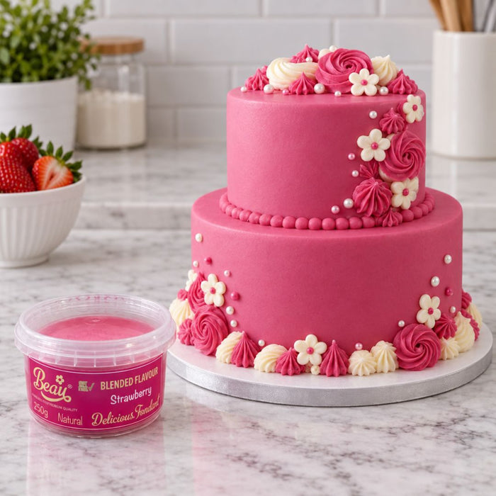 A tub of Beau's strawberry flavoured fondant sitting on a marble surface in front of a strawberry coloured cake.